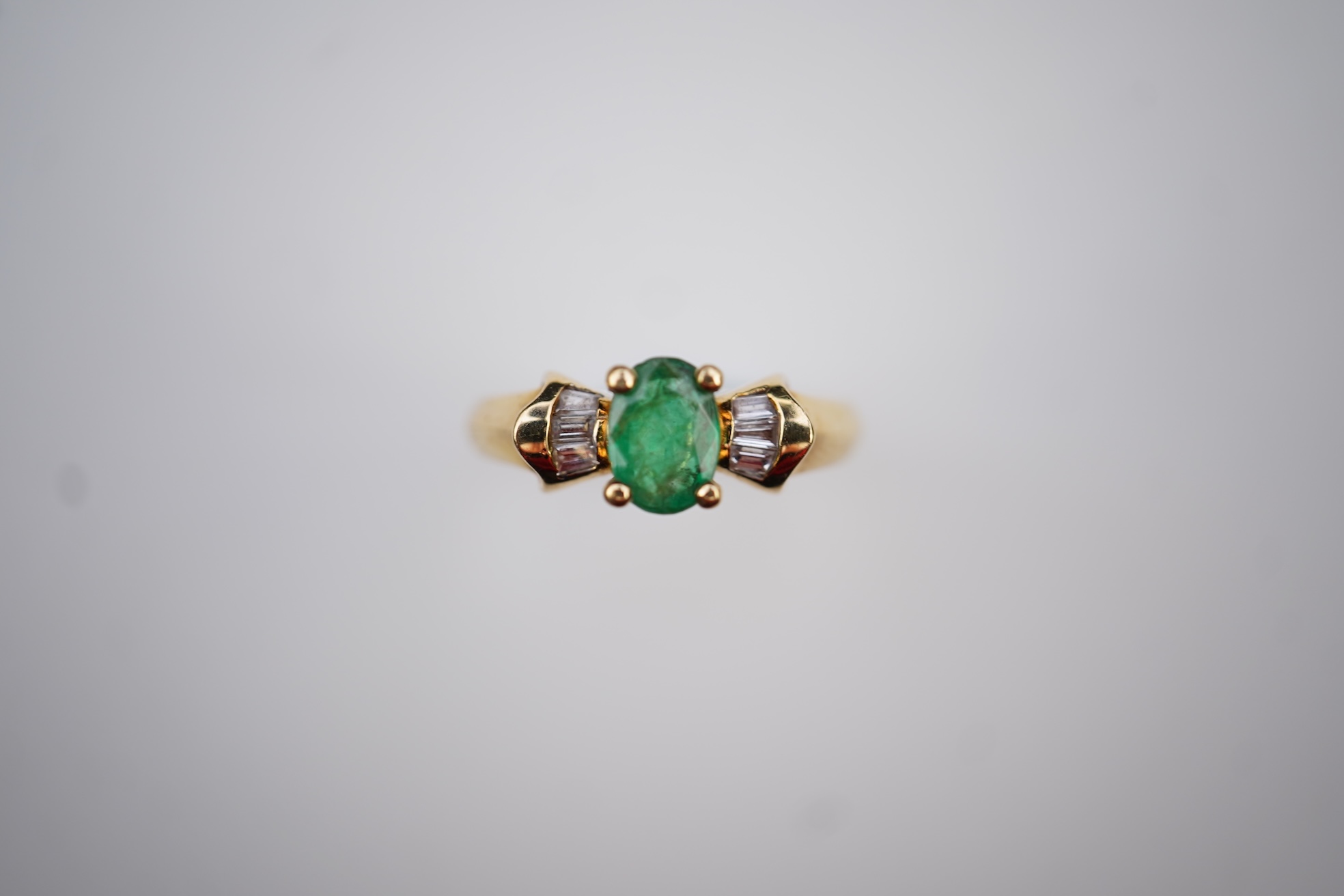 An emerald and diamond ring